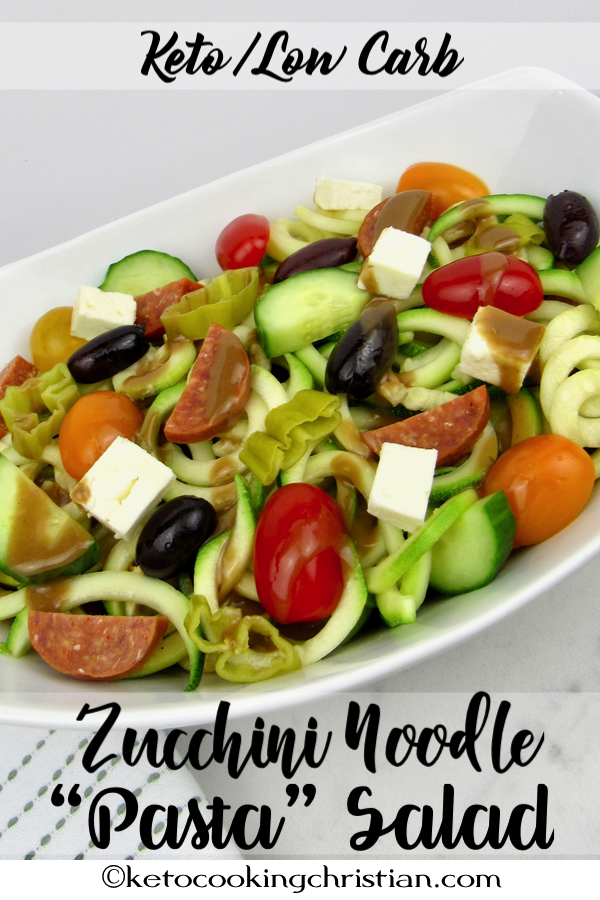 bowl of zucchini noodles with cut veggies over the top and a drizzle of balsamic dressing