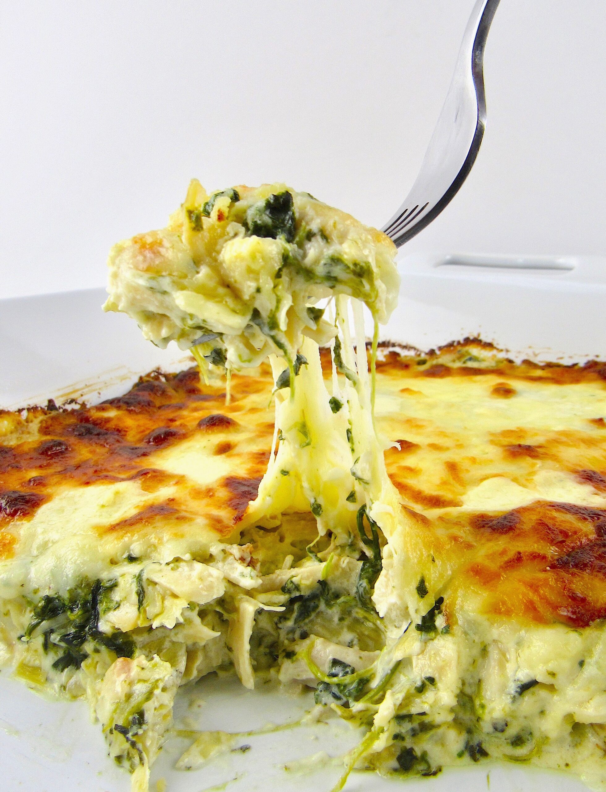 Keto Spinach Artichoke Chicken Casserole being held up with fork
