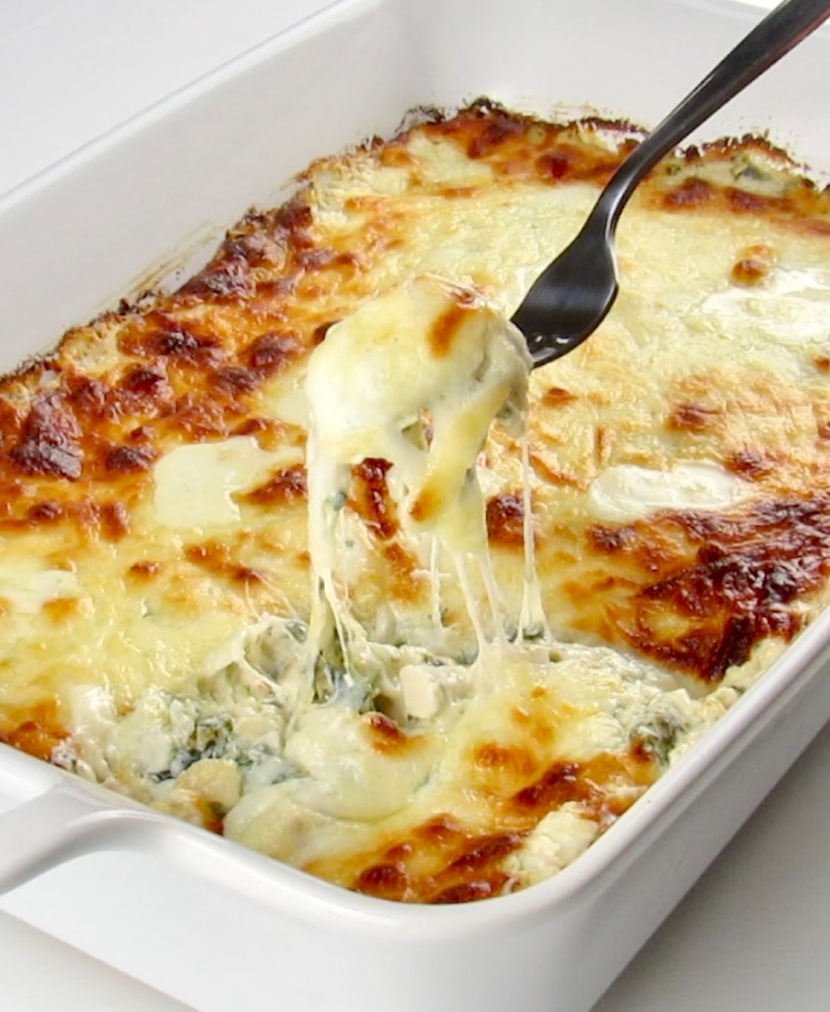 Keto Spinach Artichoke Chicken Casserole being held up with fork