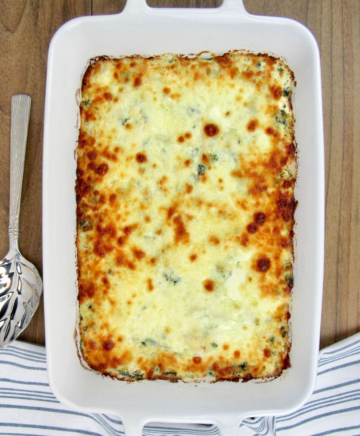overhead view of Spinach Artichoke Casserole in white casserole