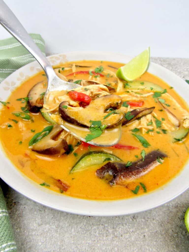 Keto/Low Carb Thai Coconut Curry Chicken Soup in Bowl with Bite on Spoon