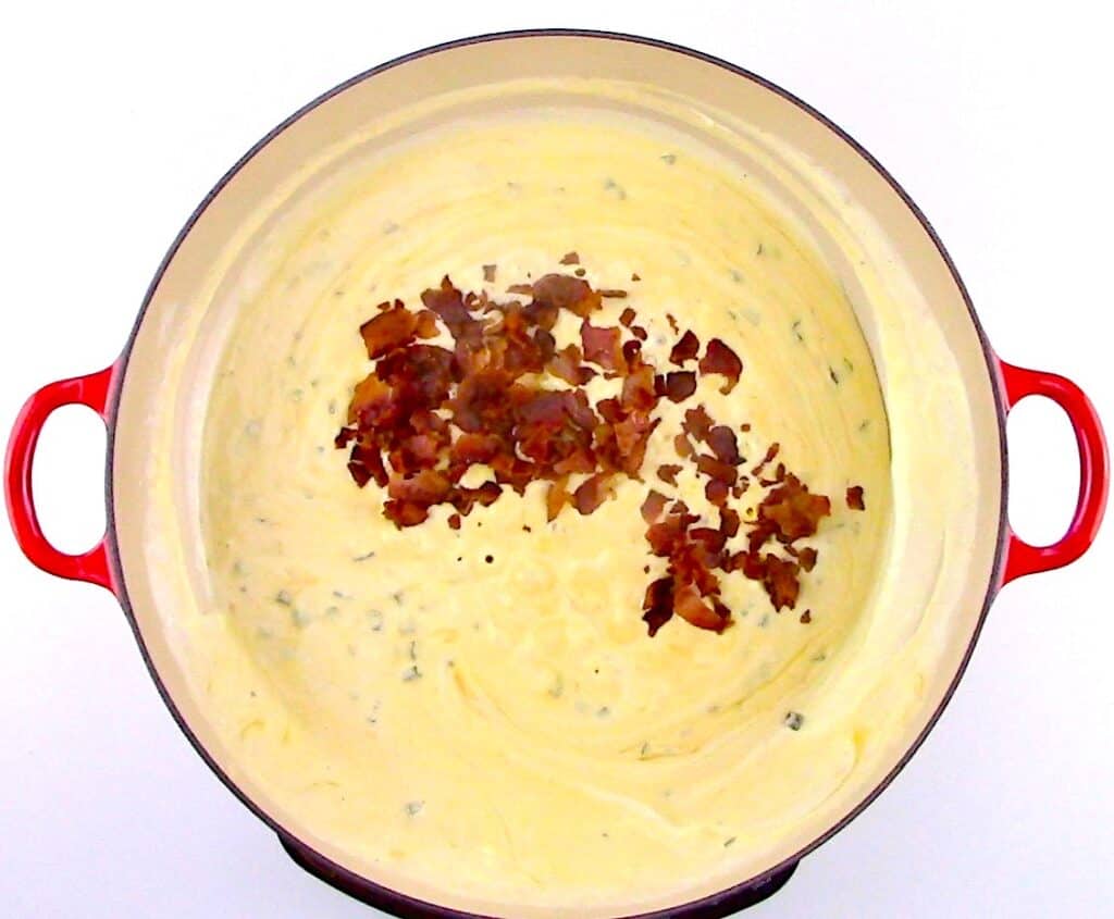cheese sauce in skillet with crumbled bacon
