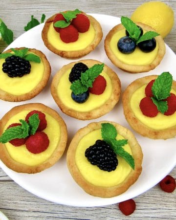 7 mini lemon curd tarts with berries on top