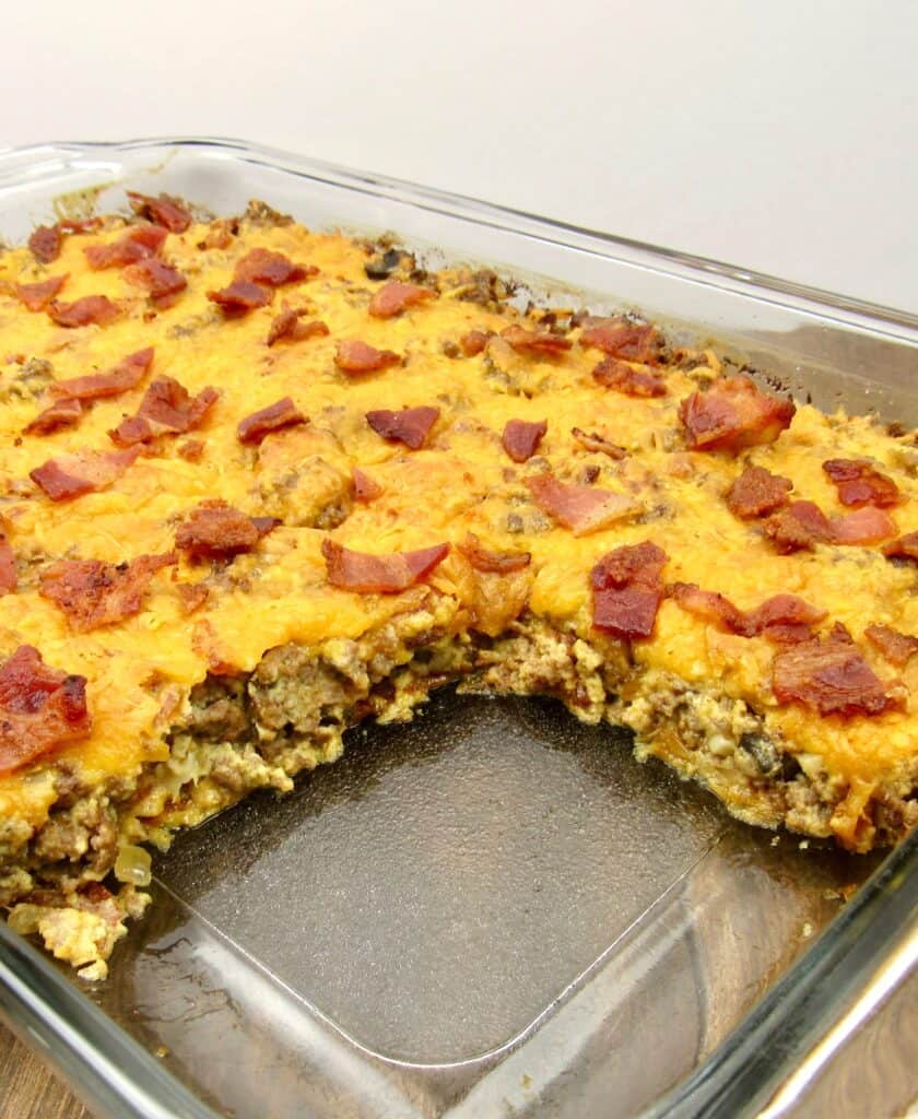 Keto/Low Carb Bacon CheeseBurger Casserole in Casserole Dish with Big Slice Missing