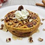 Keto Pumpkin Chaffles on plate with syrup and nuts