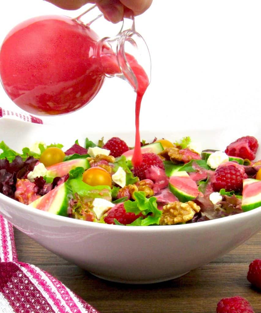Raspberry Vinaigrette being poured over a salad