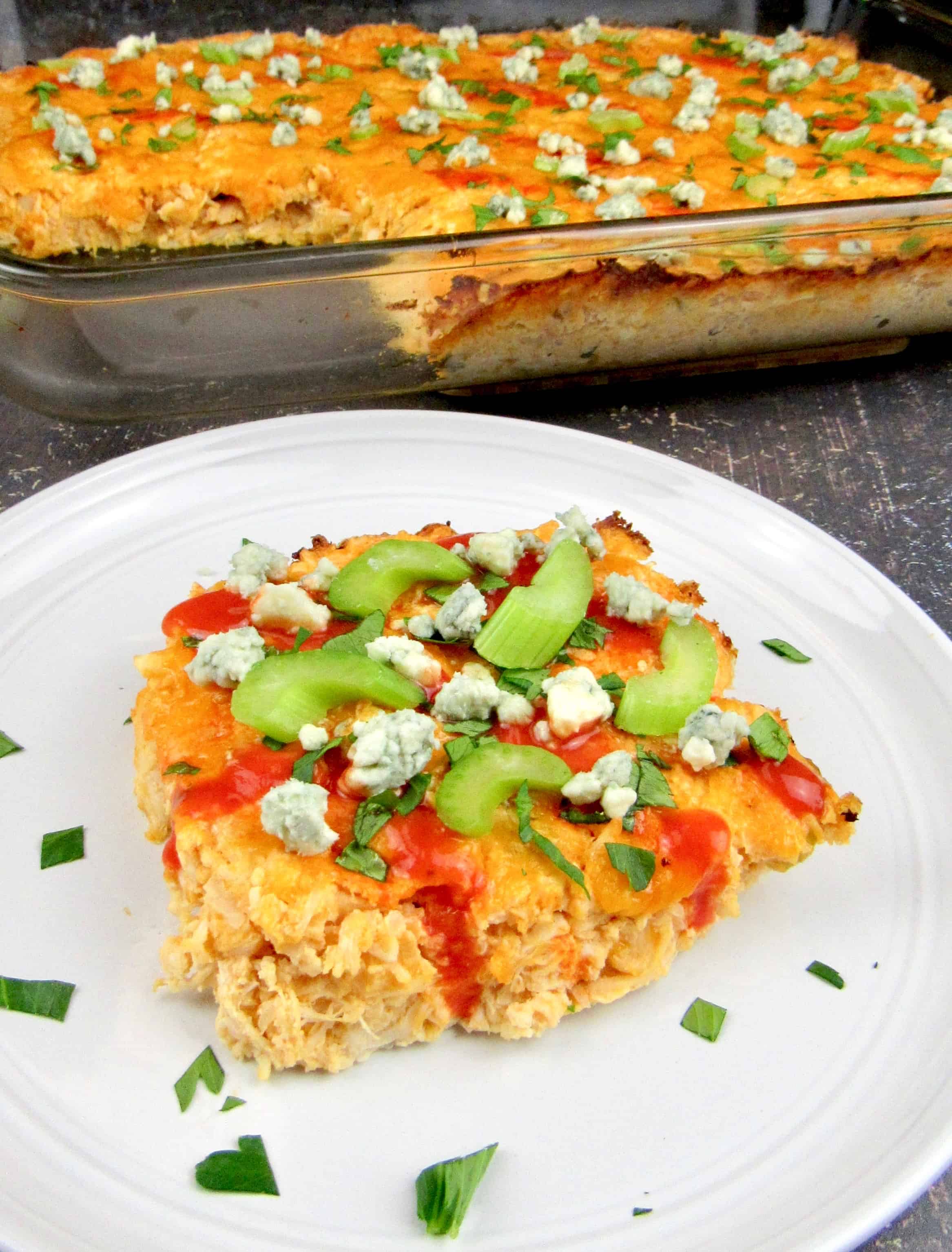 slice of buffalo chicken casserole with celery, hot sauce and blue cheese on top