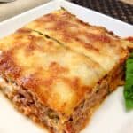 slice of zucchini lasagna with basil garnish on white plate