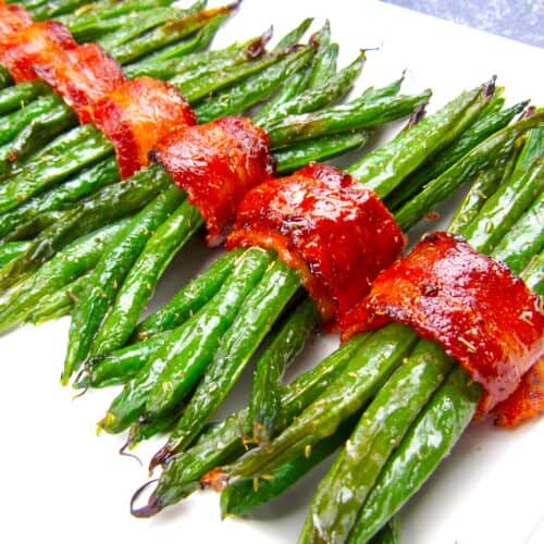bacon wrapped green beans on white plate running caddy corner