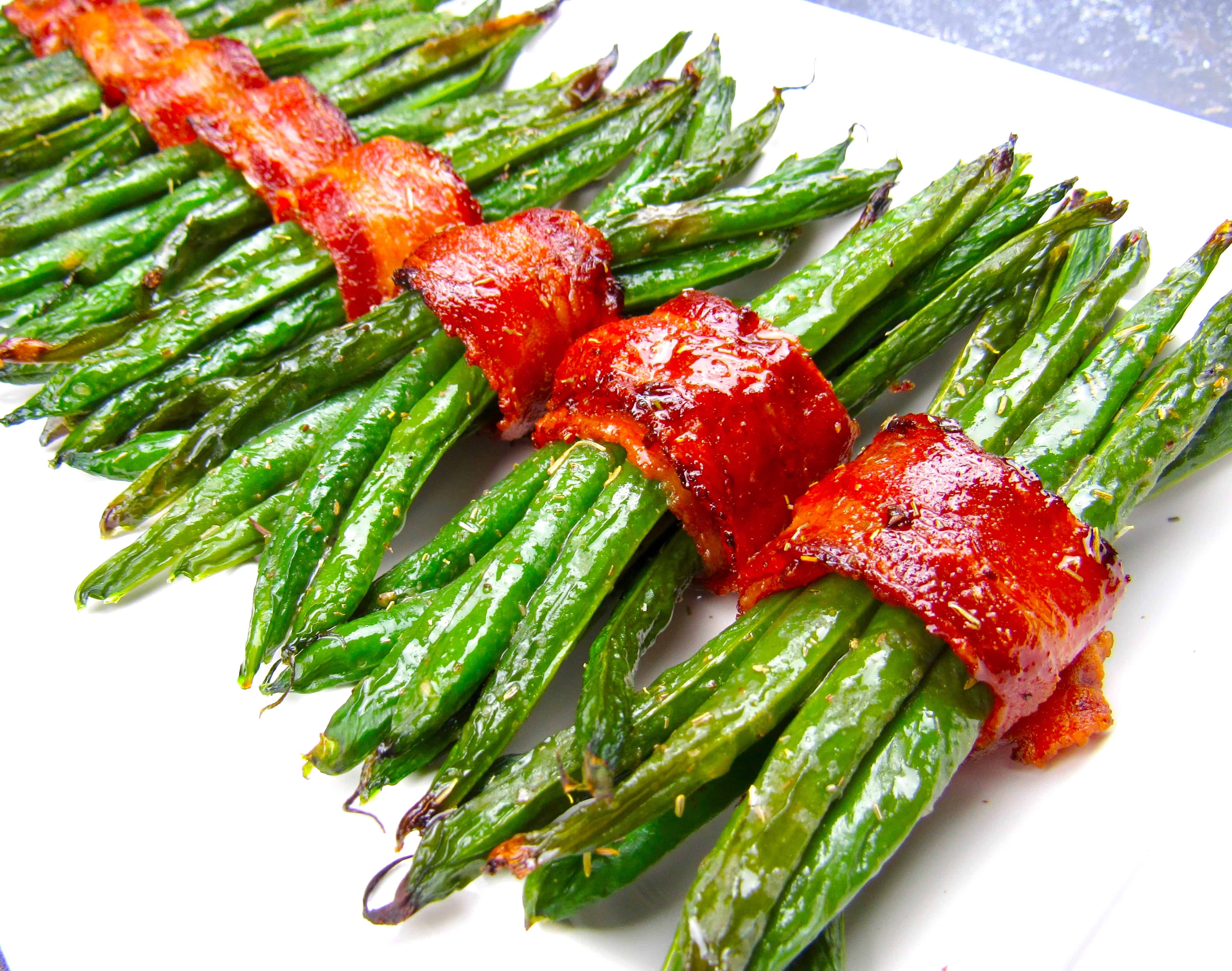 bacon wrapped green beans on white plate running caddy corner