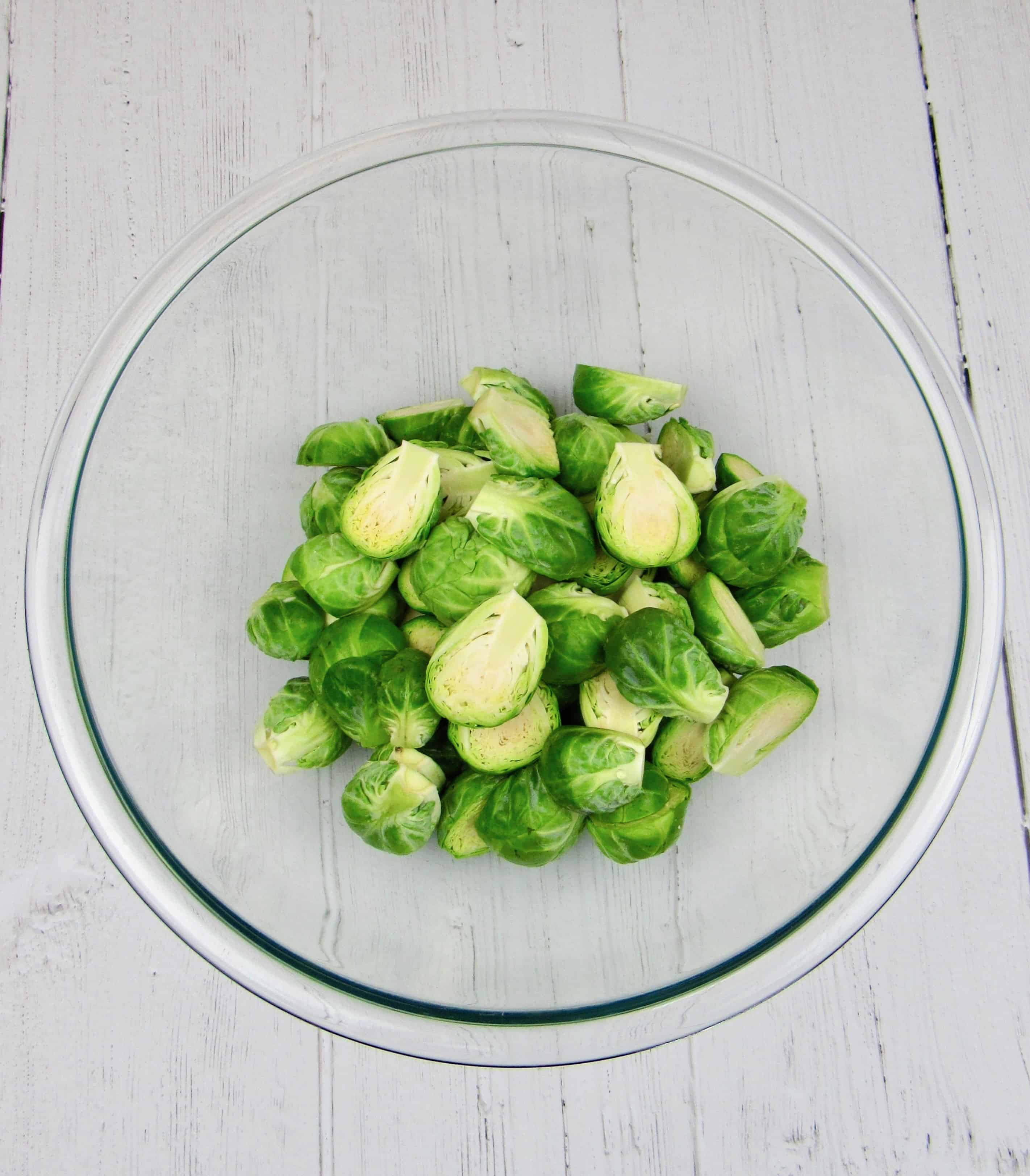 brussels sprouts cut up in glass bowl