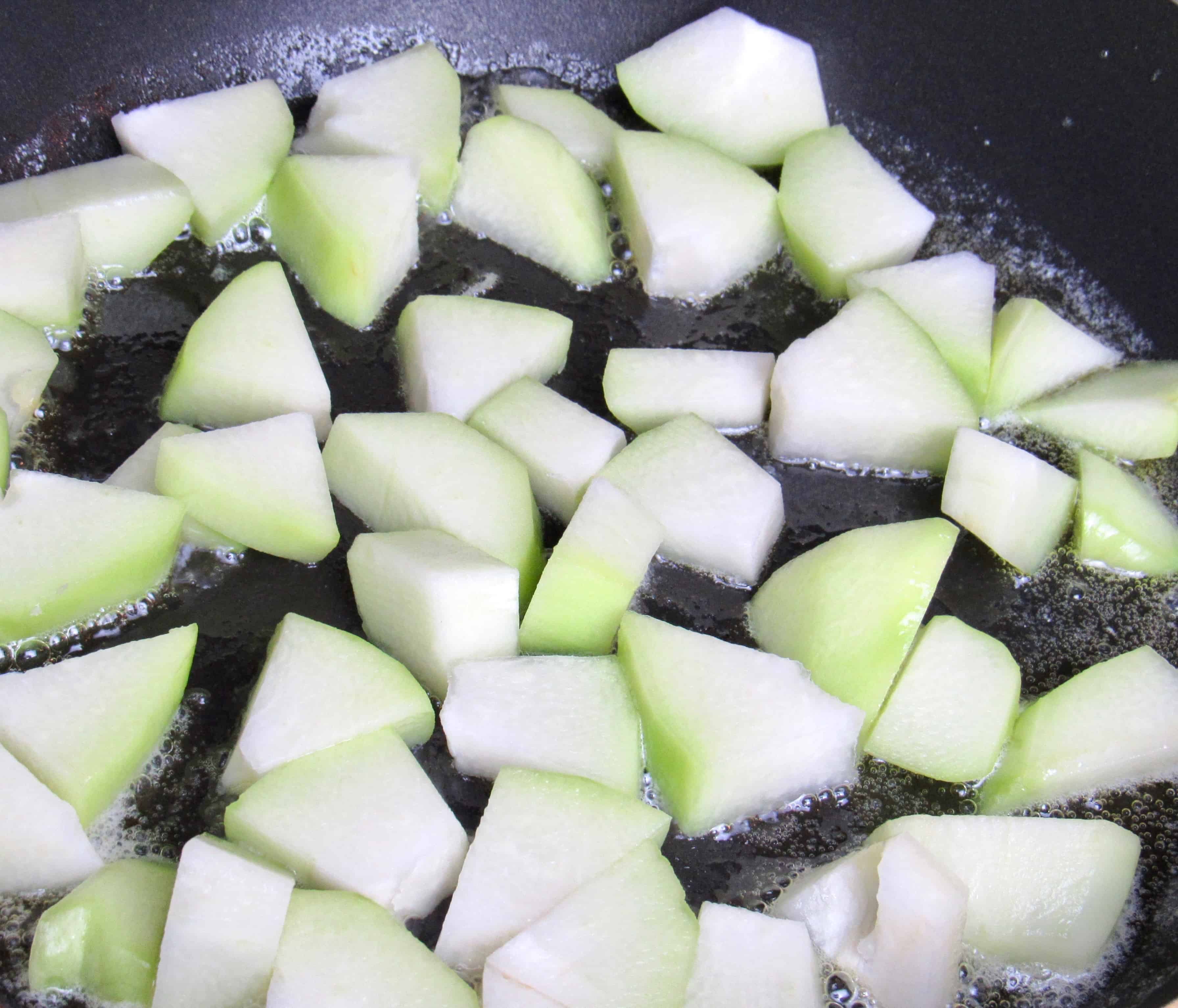 diced chayote squash in pan cooking in butter