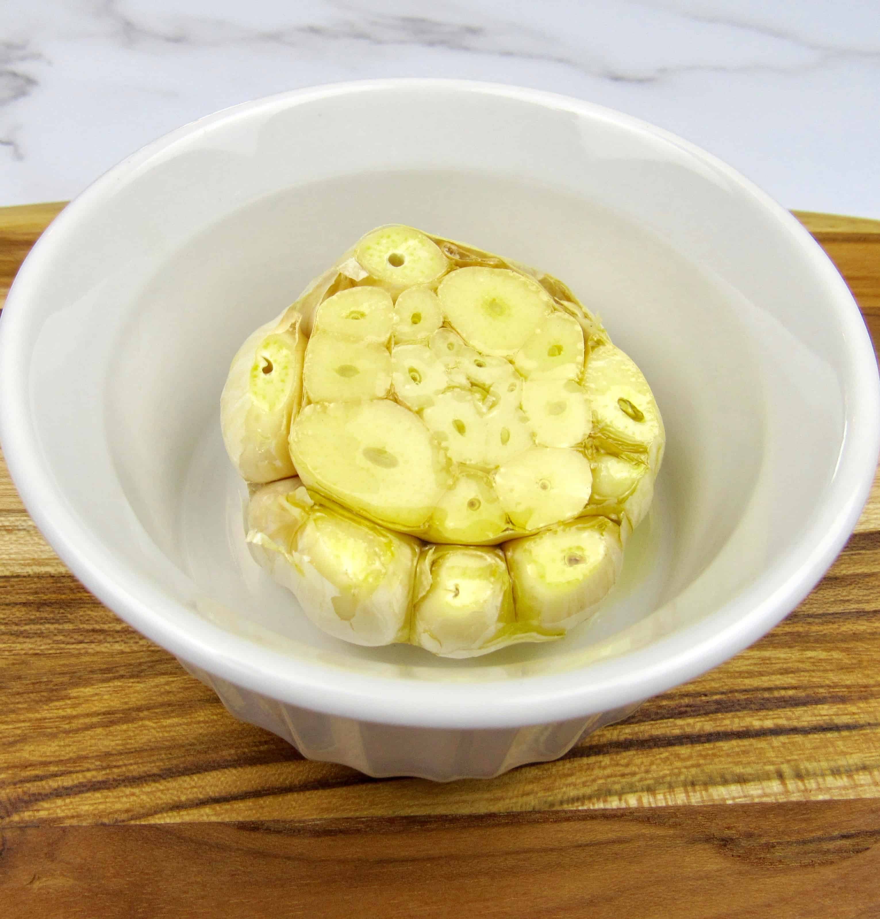 sliced head of garlic in white ramekin