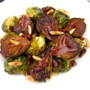 overhead view of brussels sprouts in white dish with sheet pan in background