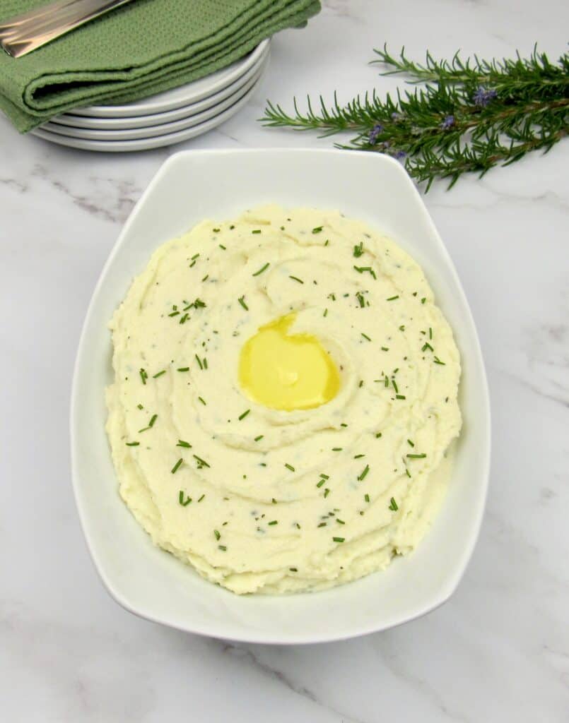 white bowl with mashed rosemary cauliflower pat of butter on top