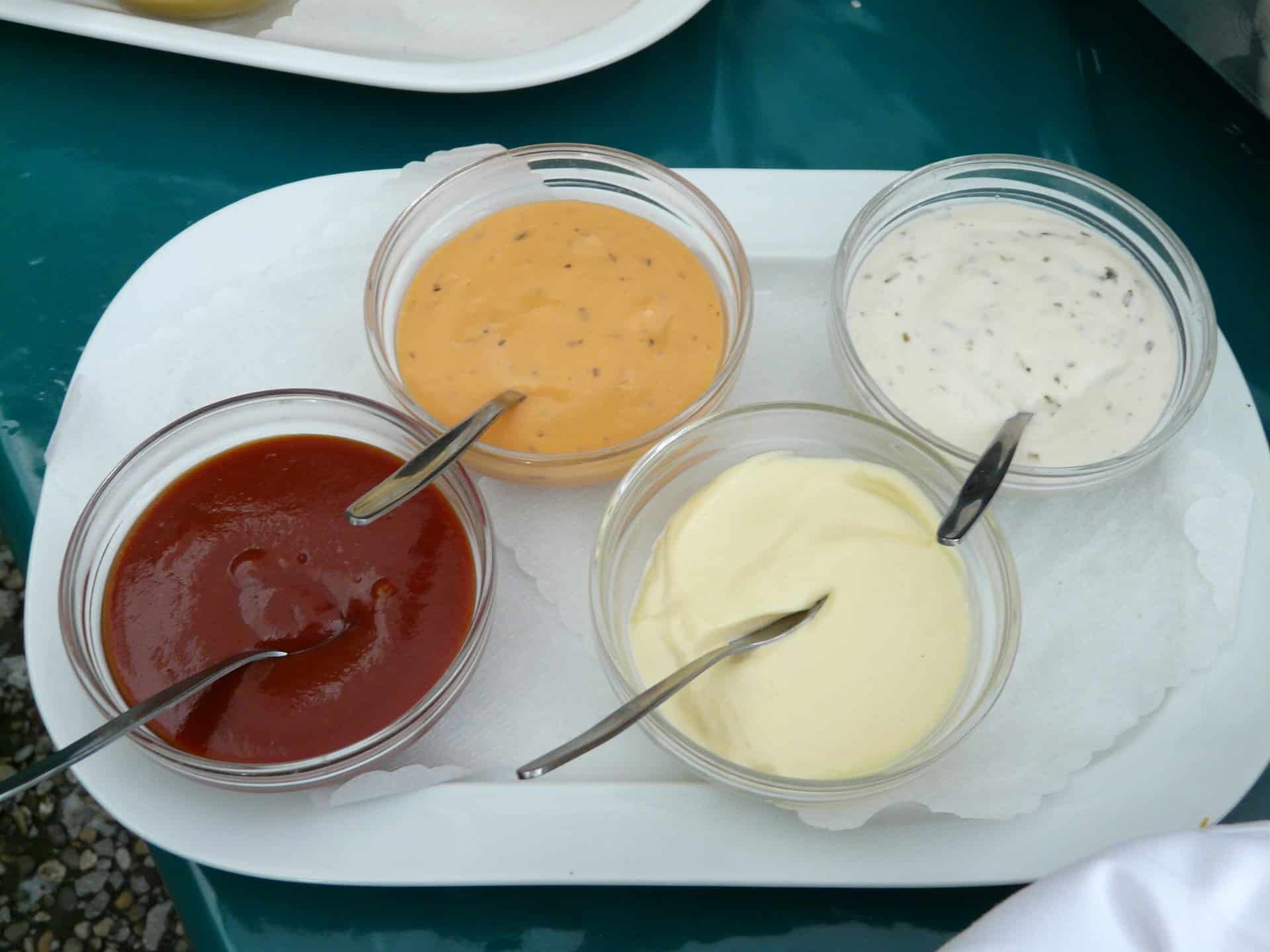 4 bowls with condiments and spoon in each