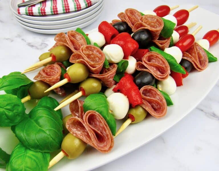 Italian antipasti skewers on white platter
