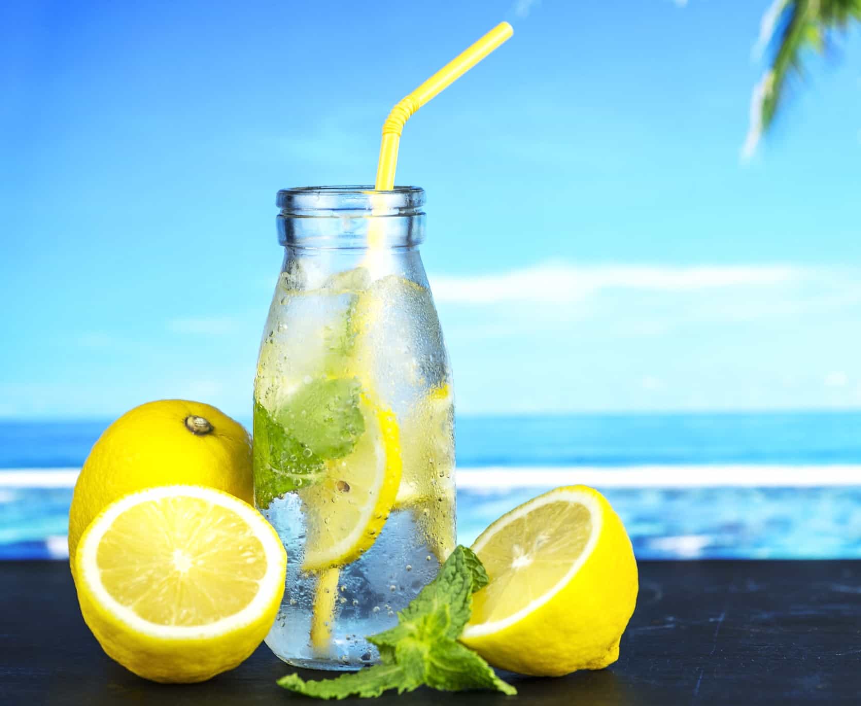 lemons in water with straw ocean in background