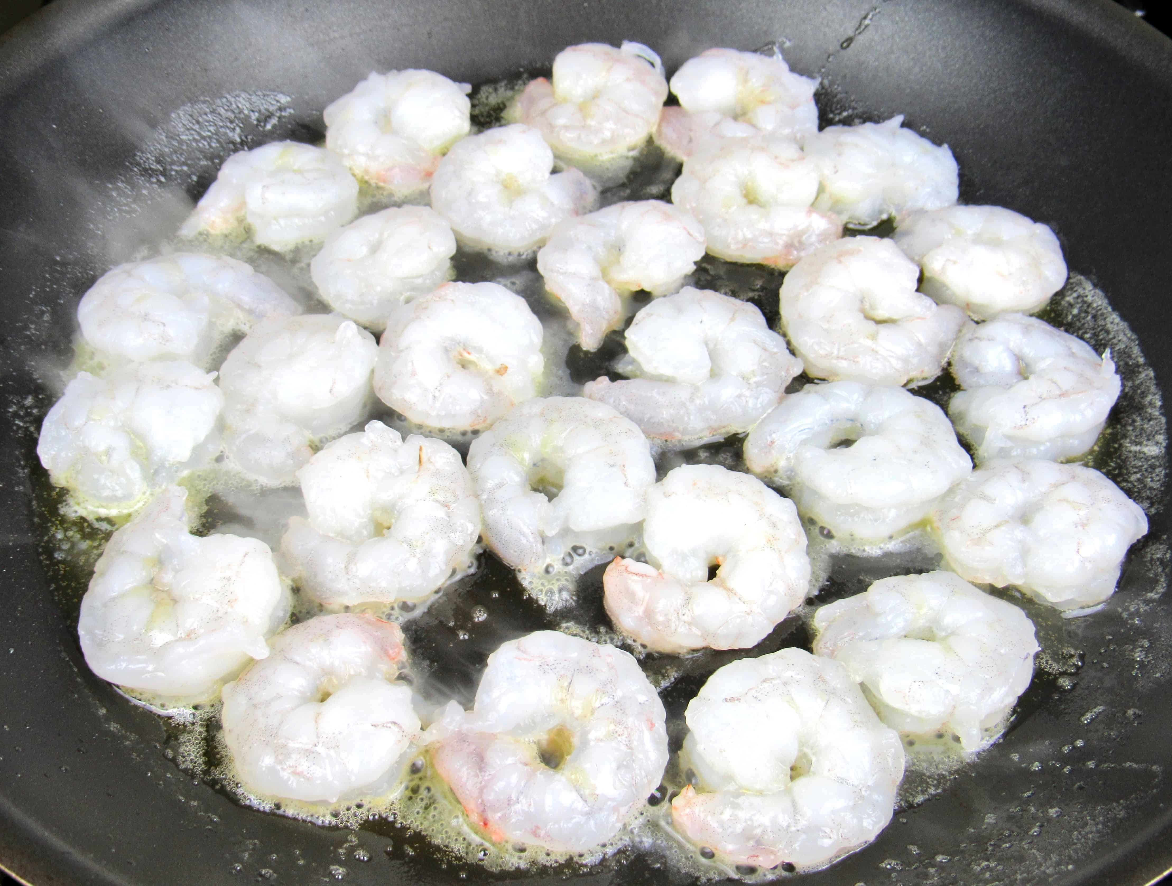 raw shrimp cooking in skillet