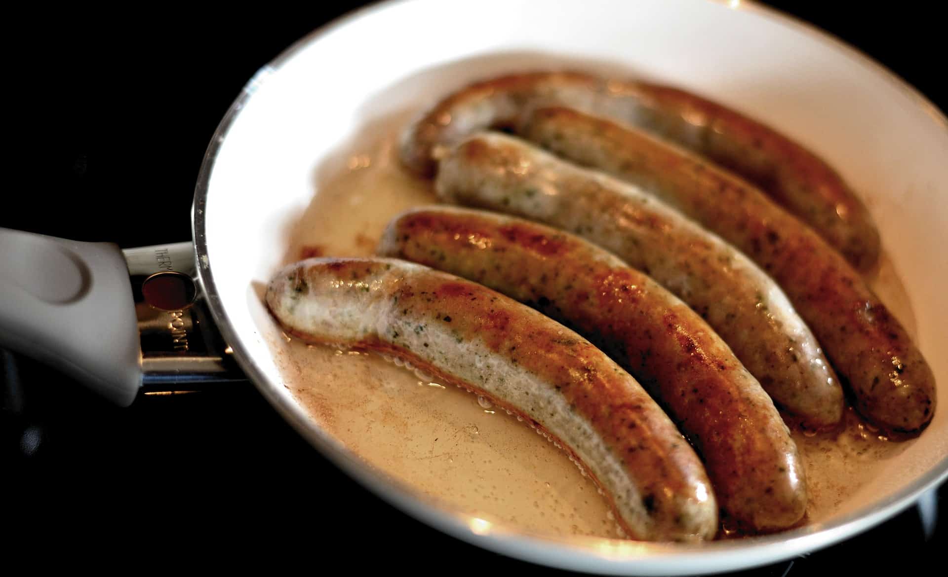 sausage frying in pan