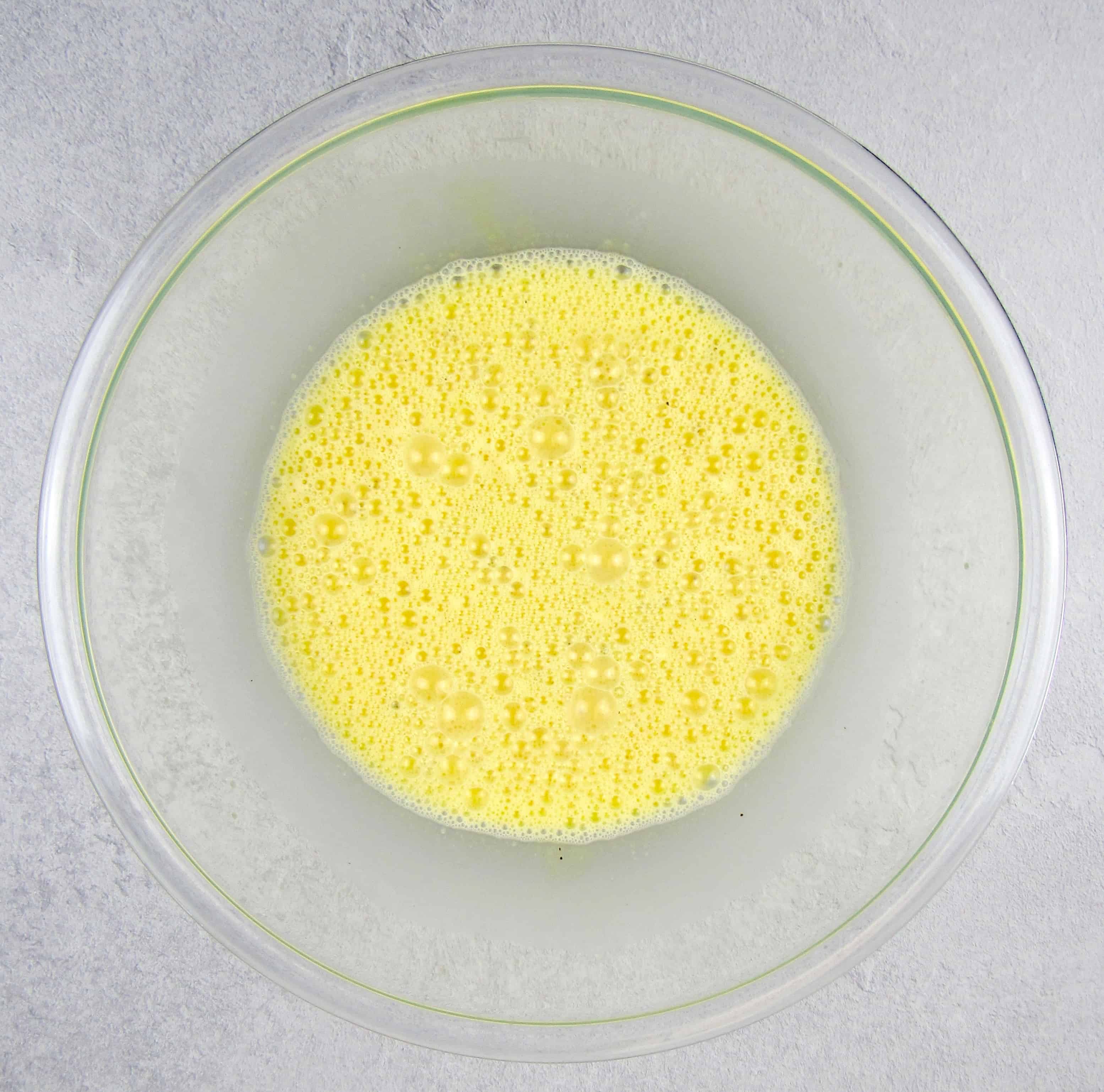 uncooked scrambled eggs in glass mixing bowl