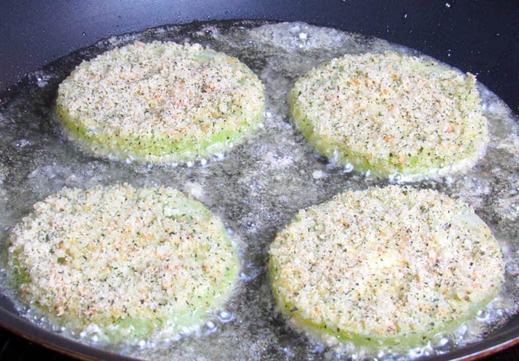 4 green tomatoes frying in pan