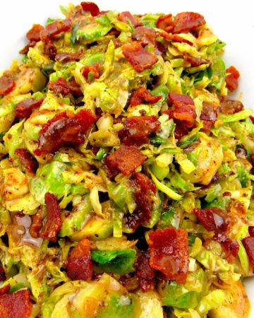 closeup of Brussels Sprouts with Hot Bacon Dressing in white bowl with bacon on top