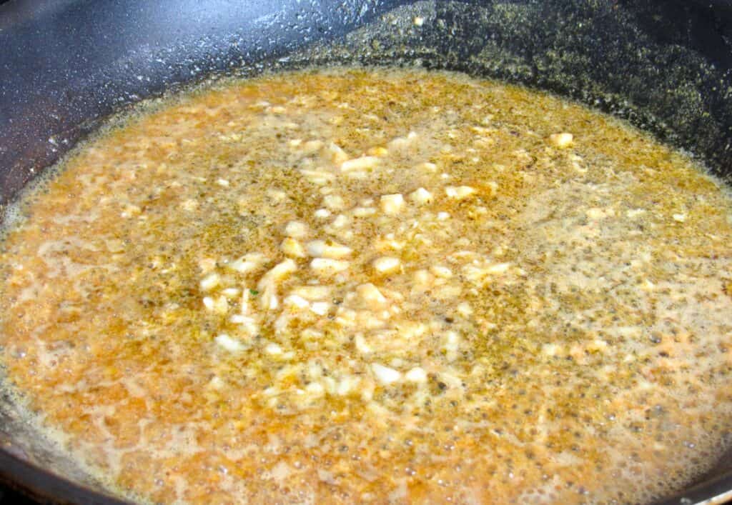 cajun salmon stock with garlic in skillet