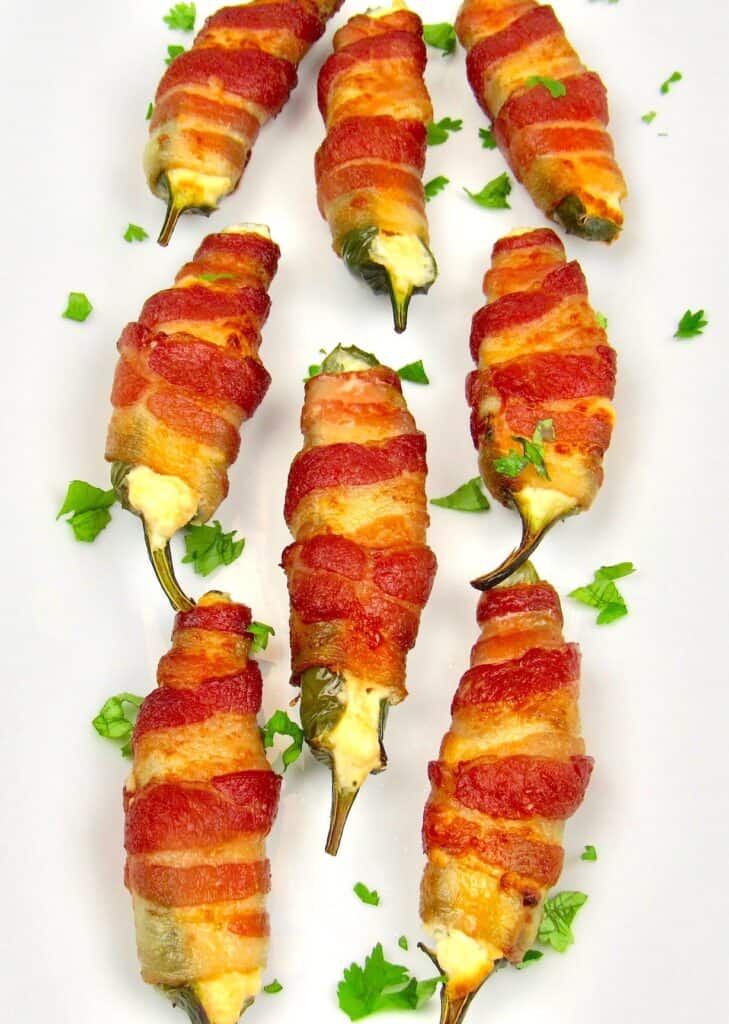 overhead view of bacon wrapped jalapeño poppers on white plate