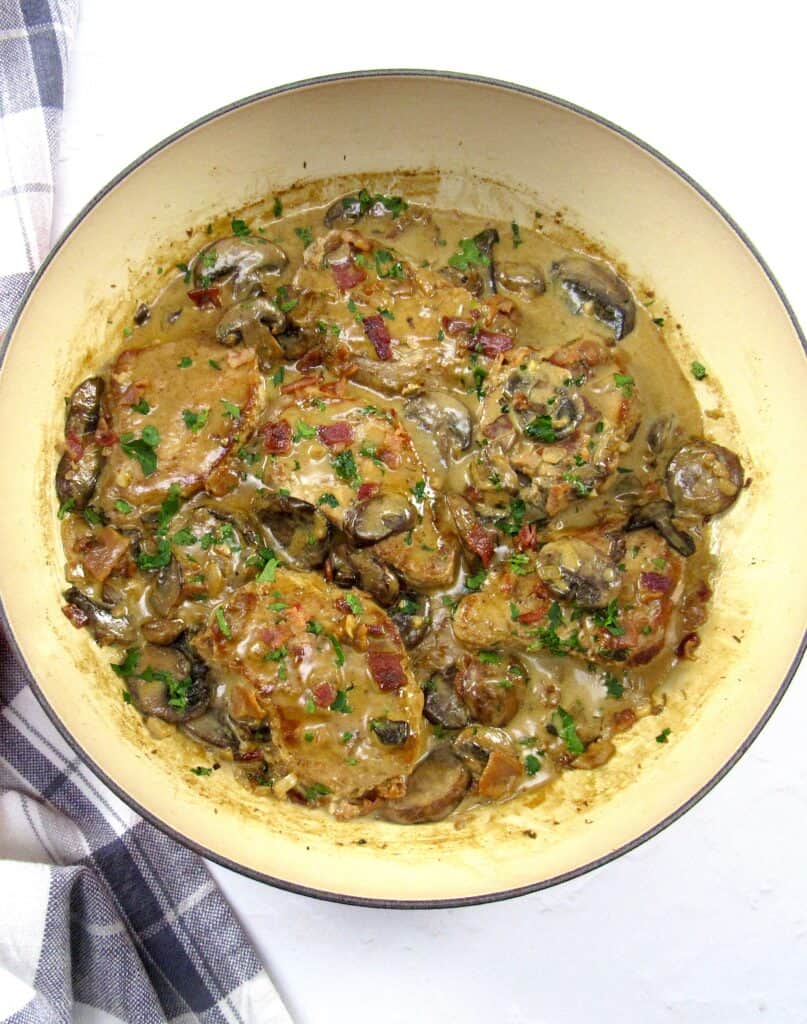 overhead view pork chop with mushroom gravy in skillet