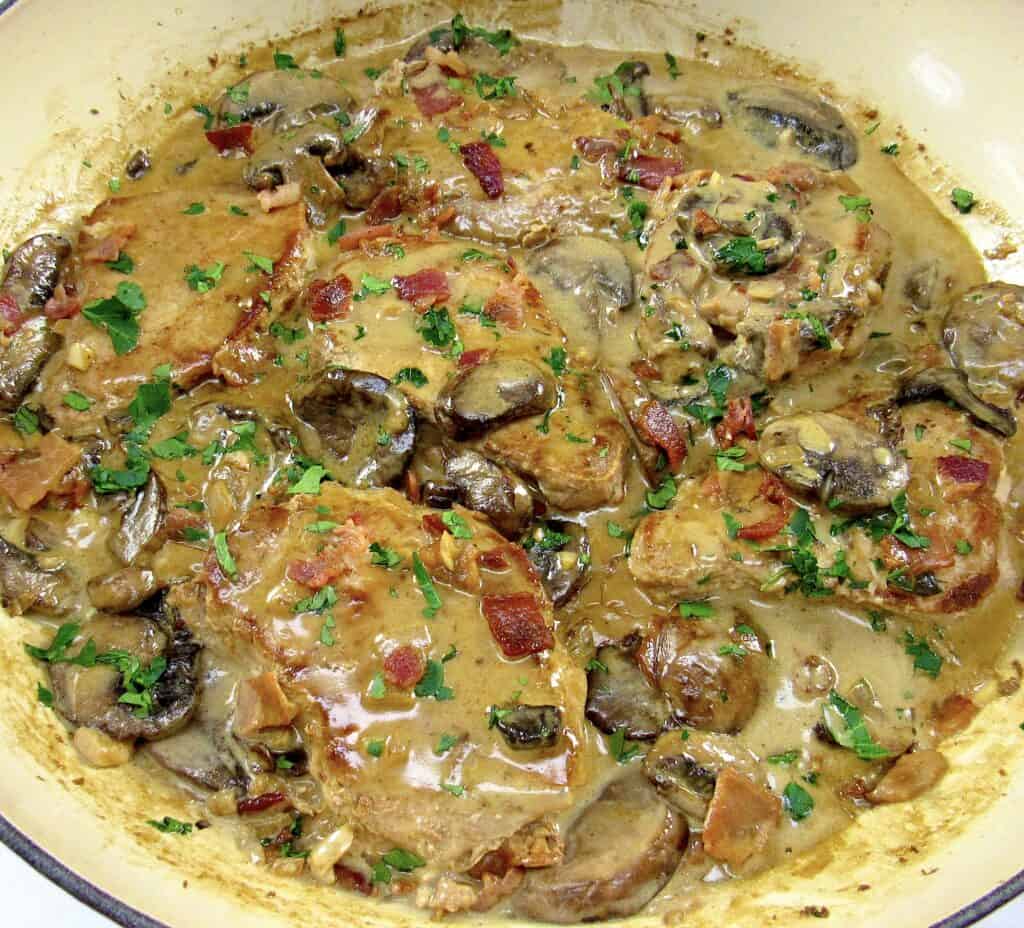 closeup pork chop with mushroom gravy in skillet