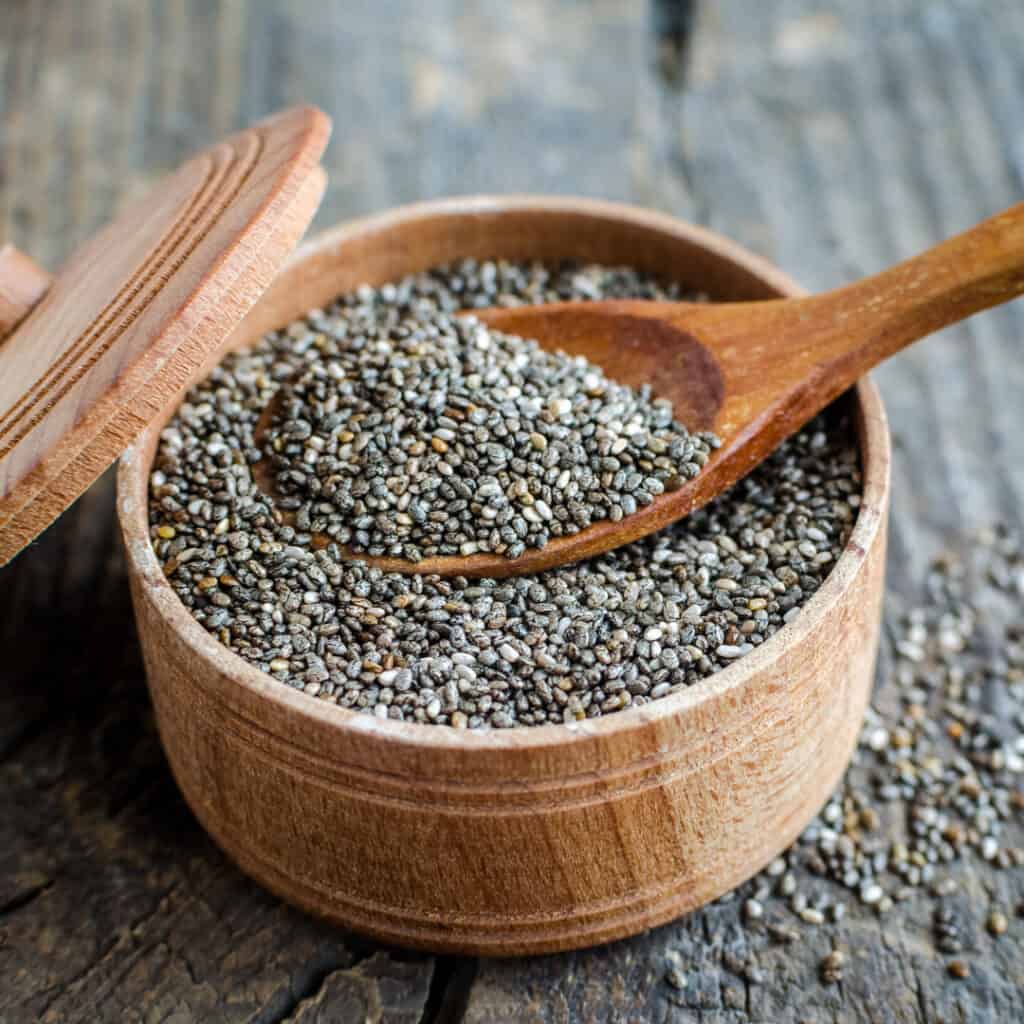 Chia Seeds in wooden bowl with wooden spoon in it