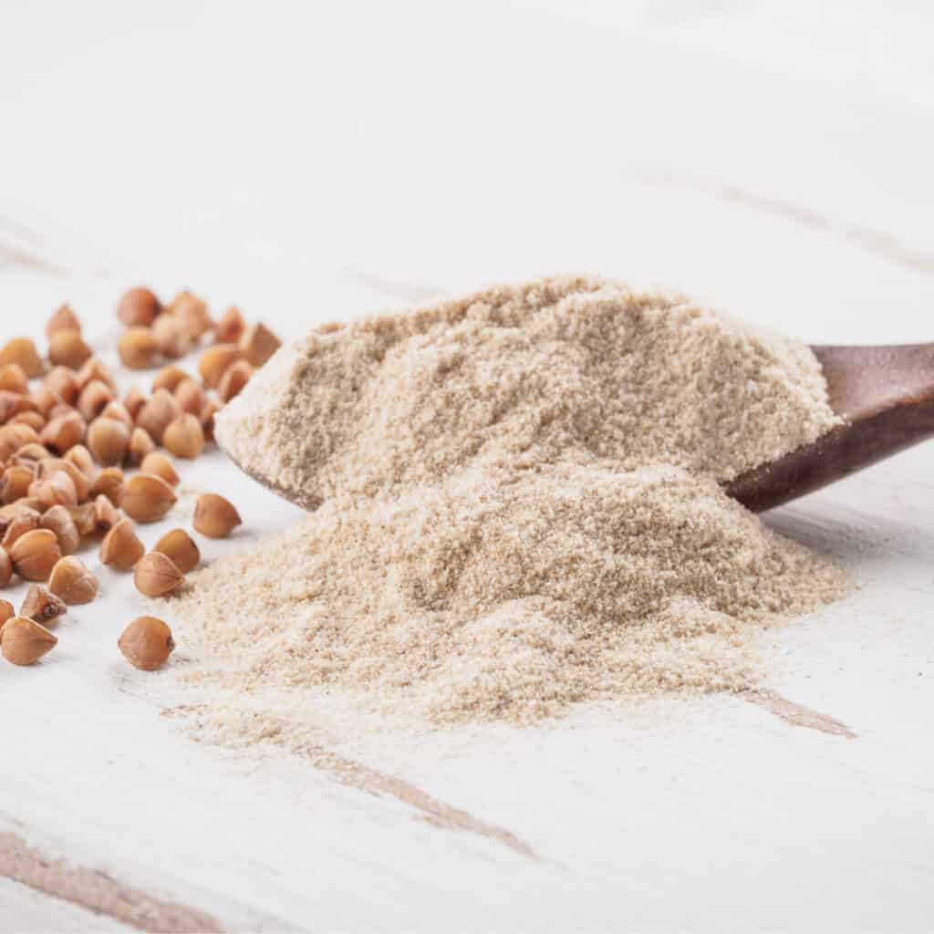 Hazelnut Flour on board with hazelnuts in background