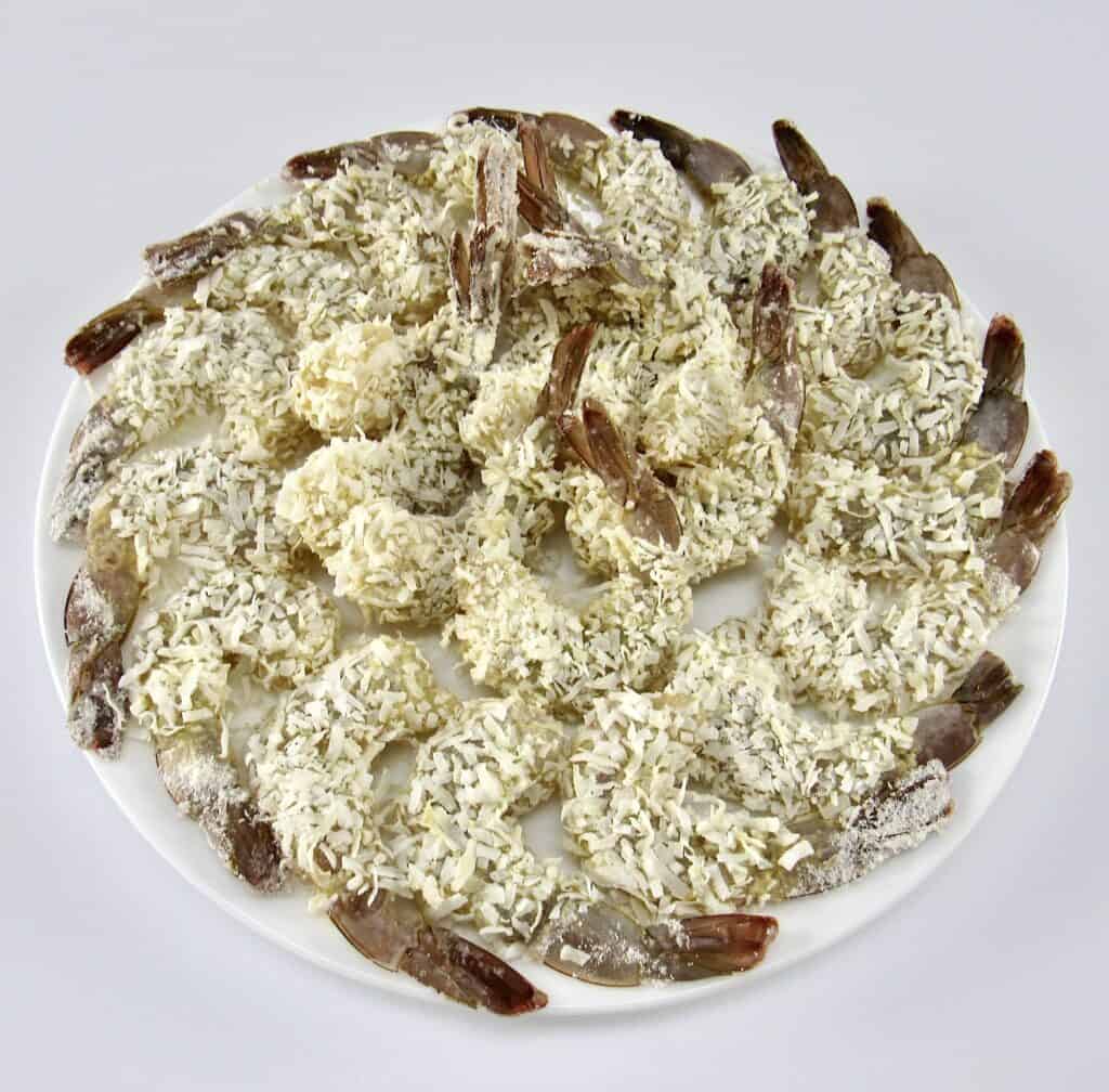 raw shrimp coated in coconut on white plate