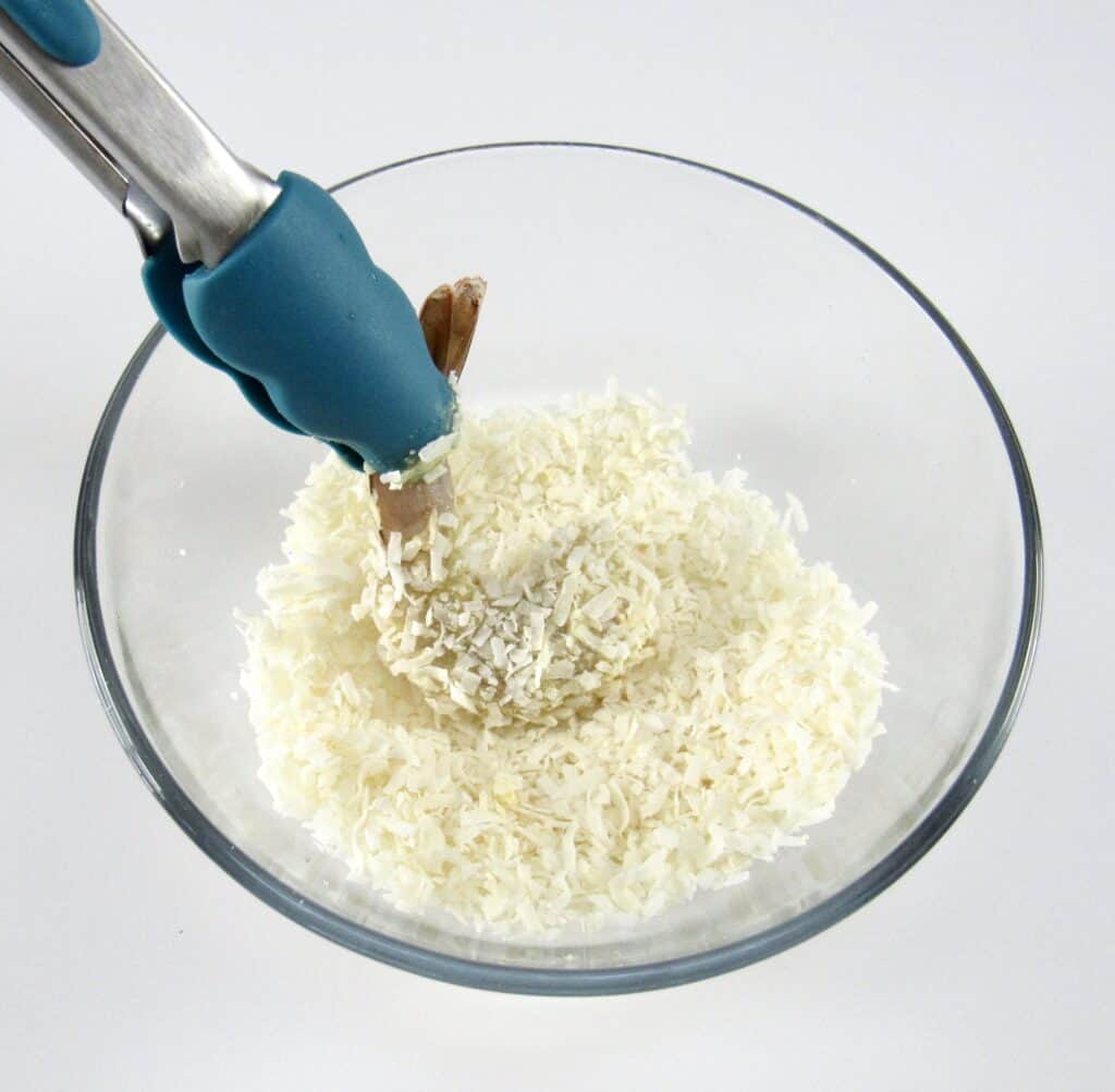 shrimp being dipped into shredded coconut