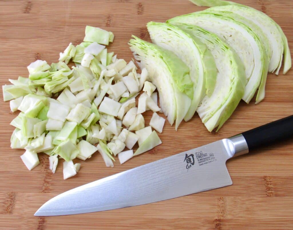 chopped cabbage on cutting board with knife