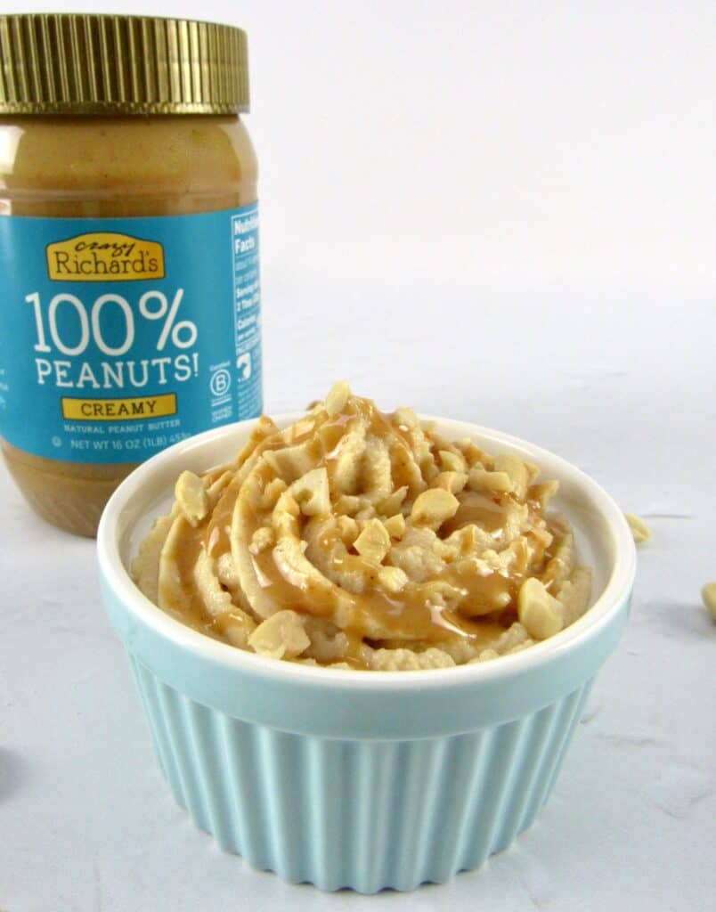closeup of peanut butter mousse in turquoise ramekin with crazy richard's peanut butter in background