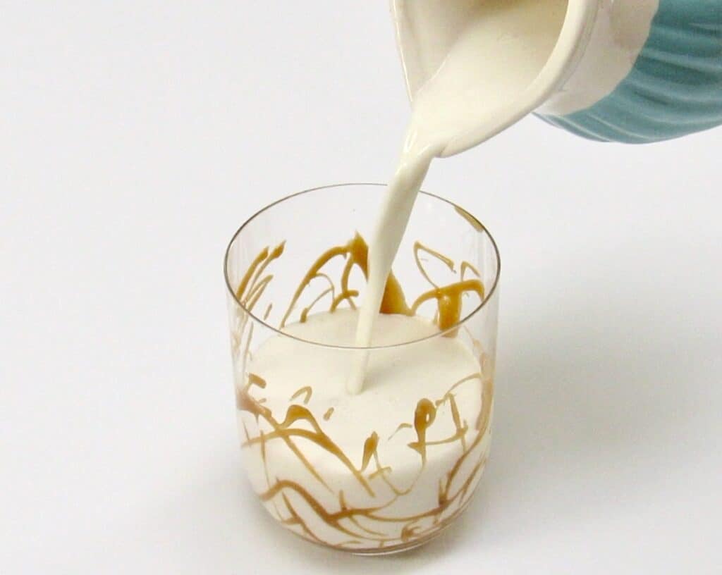 salted caramel covered glass with milk being poured into it