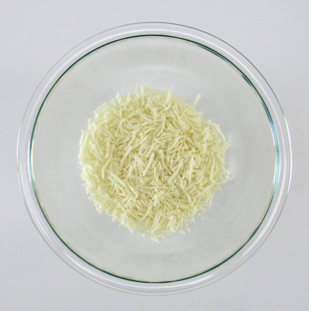 shredded mozzarella cheese in glass bowl