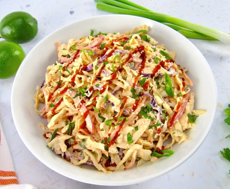 spicy coleslaw in bowl with sauce on top