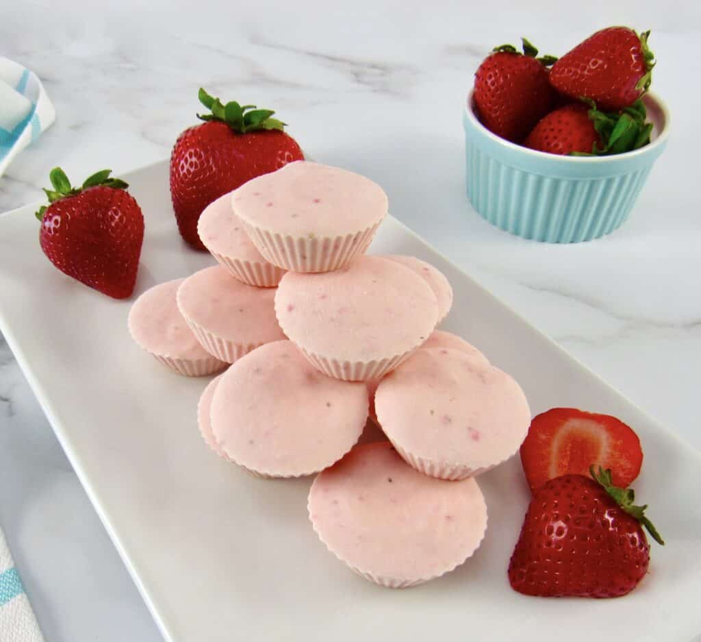 Strawberry Cheesecake Fat Bombs on white plate with strawberries