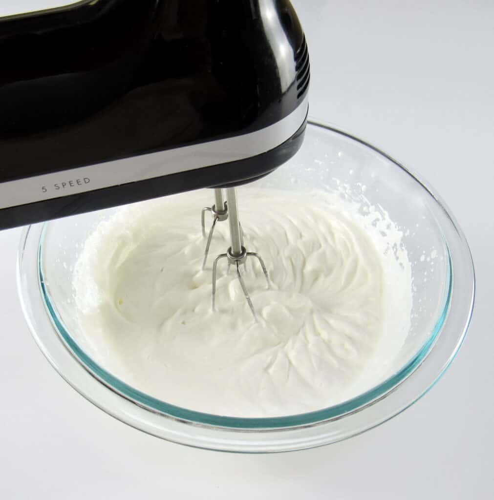 heavy cream being whipped with hand mixer