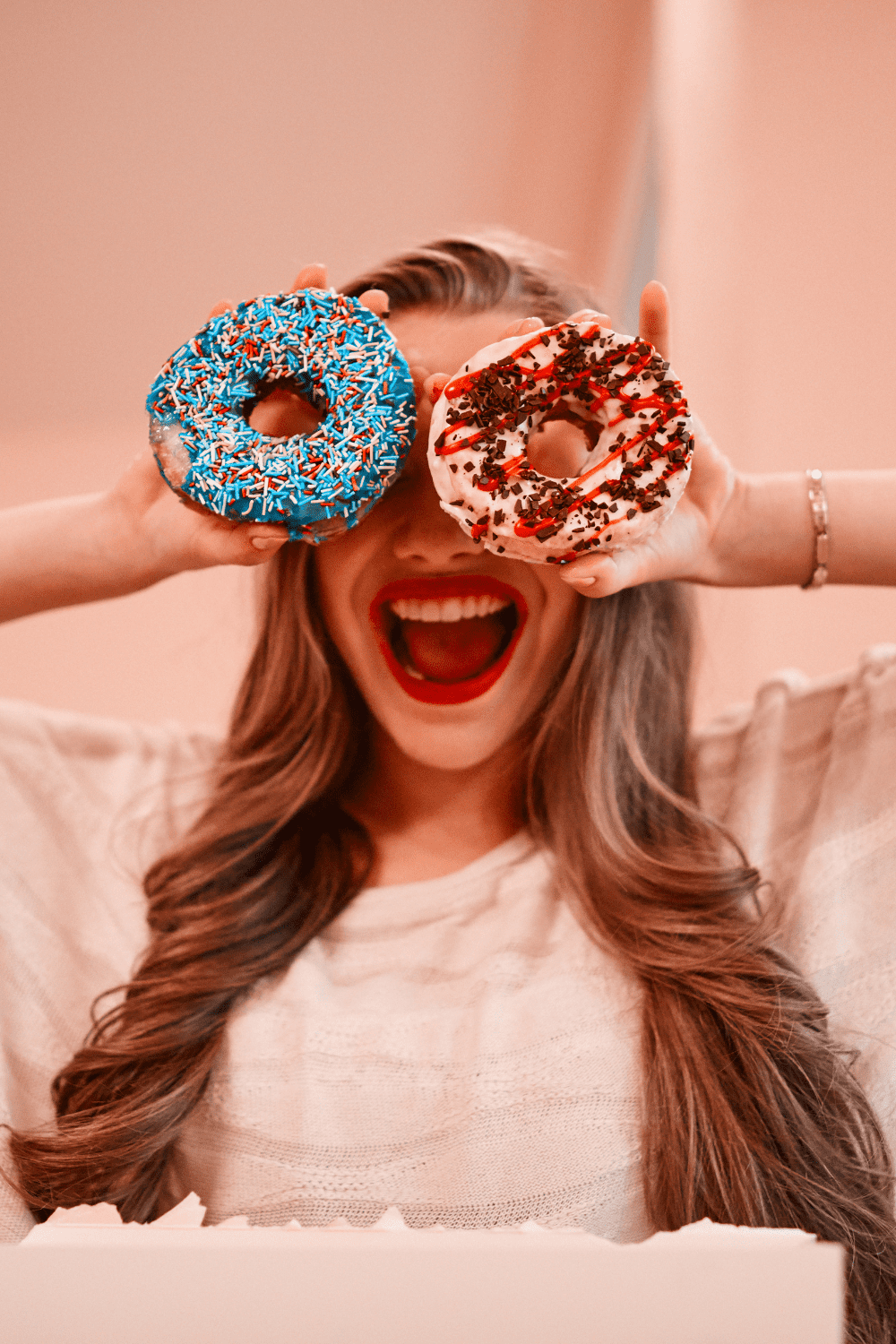 girl holding up donuts over her eyes