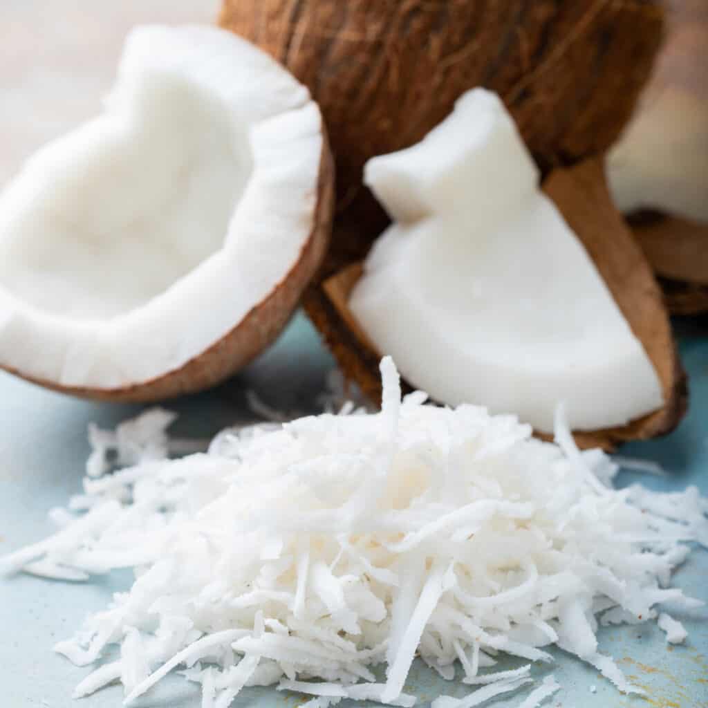 Shredded Coconut with fresh cut open coconuts in background