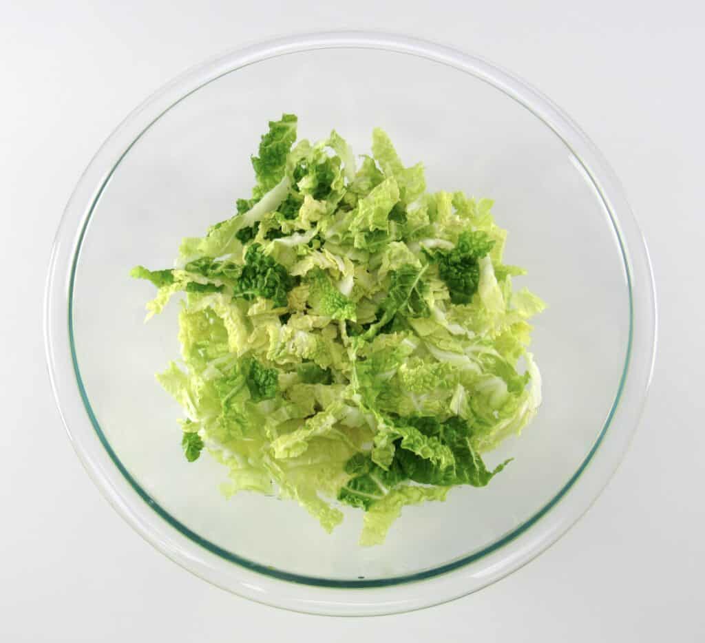 shredded napa cabbage in glass bowl