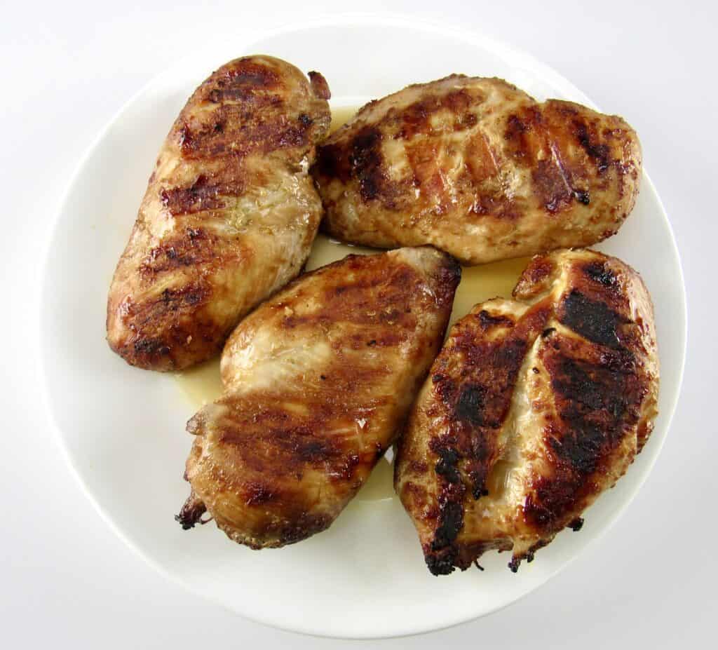 4 grilled chicken breasts on white plate