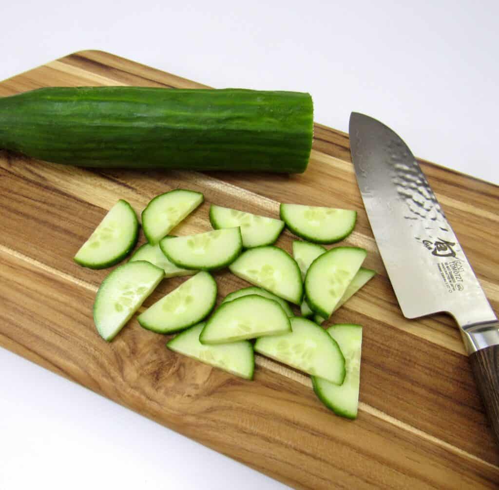 sliced cucumbers and knife on cutting board
