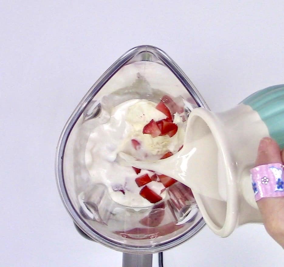 milk being poured into blender bowl