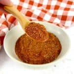 blackened seasoning mix in bowl with wooden spoon holding up some