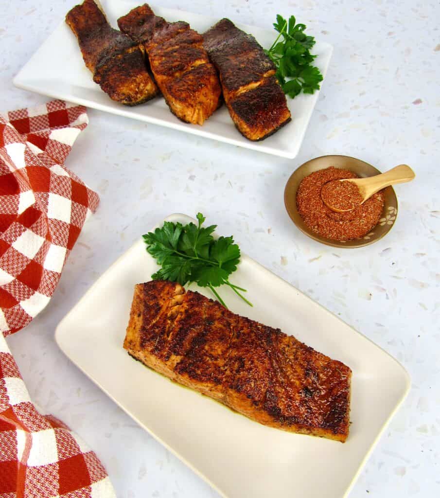 blackened salmon on plate with spices and 3 more pieces in background